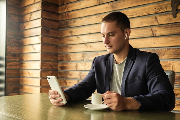 Homme d'affaires à l'écoute sur les écouteurs de son téléphone portable