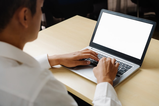 Homme d'affaires ou employé de bureau à l'aide d'un ordinateur portable alors qu'il était assis au bureau.