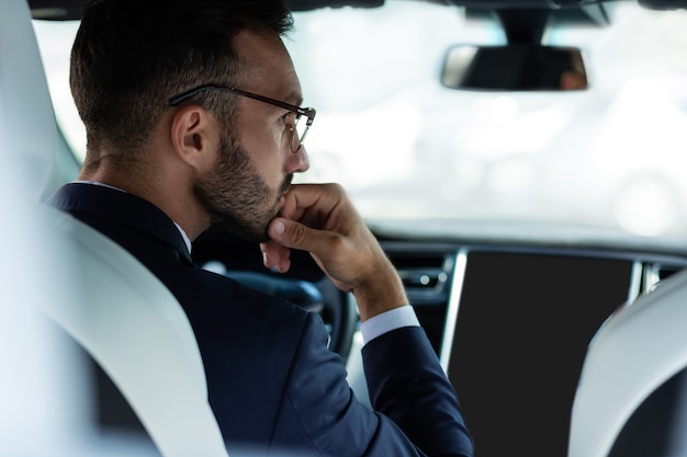 Homme d'affaires ennuyé. Homme d'affaires portant des lunettes s'ennuyer en attendant dans l'embouteillage