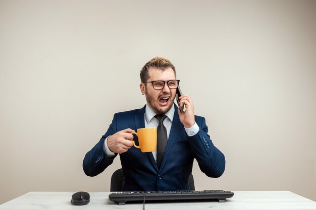 L'homme d'affaires est furieux et en colère contre l'ordinateur, un employé de bureau devient fou