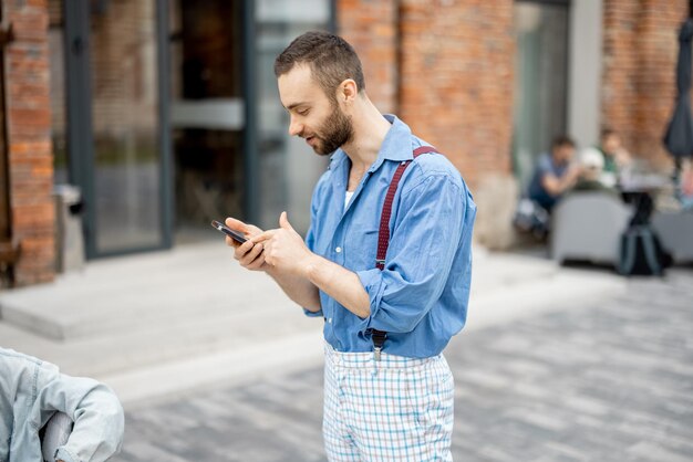 Homme d'affaires étrange avec téléphone à l'extérieur