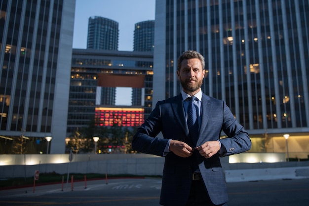 Homme d'affaires exécutif Portrait de PDG près d'un bureau moderne en costume Heureux chef debout devant le bâtiment de l'entreprise