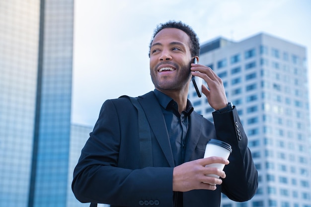 Homme d'affaires faisant un appel téléphonique avec un smartphone à l'extérieur sur la rue de la ville marchant et parlant