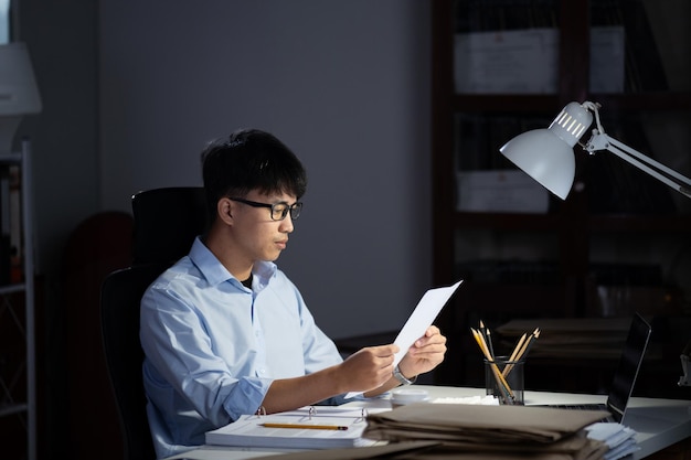 Un homme d'affaires faisant des heures supplémentaires dans son bureau. Il se sentait fatigué.