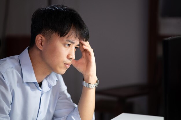 Photo un homme d'affaires faisant des heures supplémentaires dans son bureau. il se sentait fatigué.