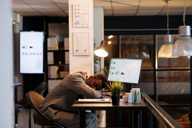 Un homme d'affaires fatigué dormant sur une table de bureau dans un bureau de start-up