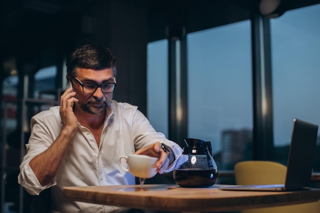 Un homme d'affaires fatigué renverse du café sur la tablexA