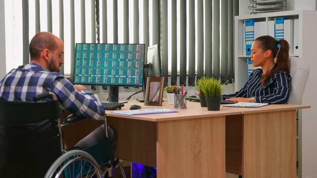 Photo homme d'affaires en fauteuil roulant travaillant dans un bureau d'entreprise