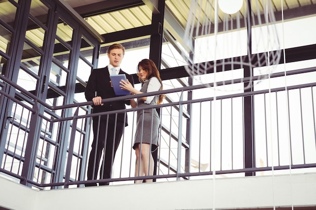 Homme d'affaires et femme d'affaires à l'aide de tablette numérique au bureau