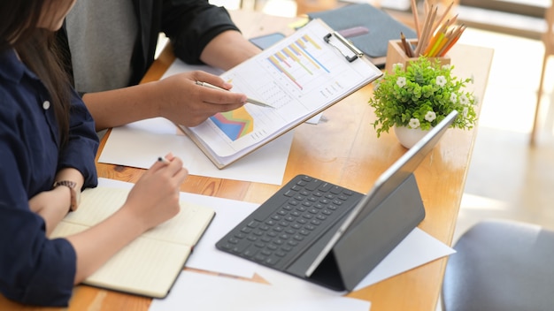 Homme d&#39;affaires et femme d&#39;affaires assis à table travaillant avec des données