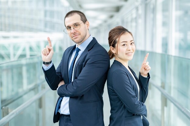 Homme d'affaires et femme d'affaires debout dos à dos dans le bâtiment