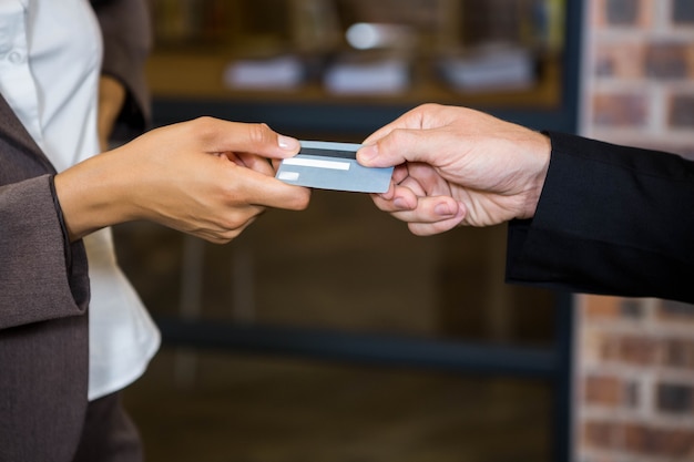 Photo homme d'affaires et femme d'affaires détenant une carte de crédit au bureau