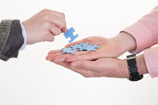 Homme d'affaires et femme d'affaires donne des pièces de puzzle au bureau