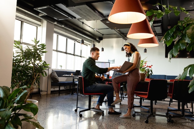 Photo homme d'affaires et femme d'affaires multiraciaux discutant de la stratégie commerciale sur un dossier dans un bureau de création