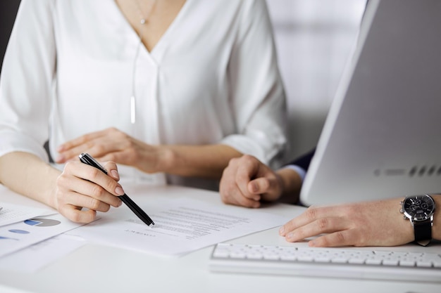 Homme d'affaires et femme inconnus discutant d'un contrat au bureau. gros plan. Gens d'affaires ou avocats travaillant ensemble lors d'une réunion. Travail d'équipe et partenariat.