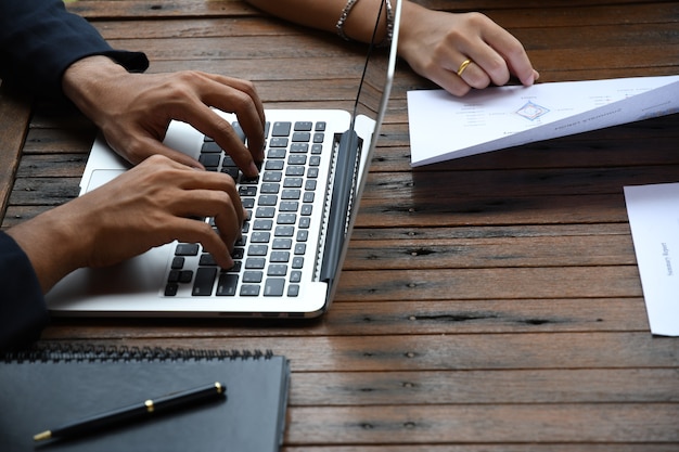 Homme d'affaires et femme travaillant sur le papier de rapport au bureau extérieur avec équipement de communication