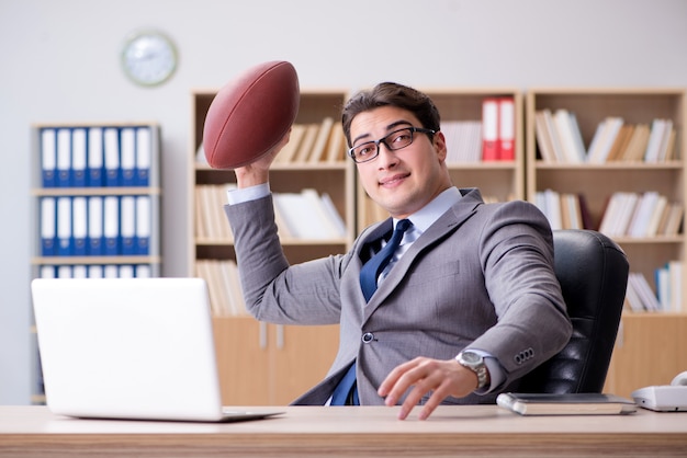 Homme d'affaires avec le football américain au bureau