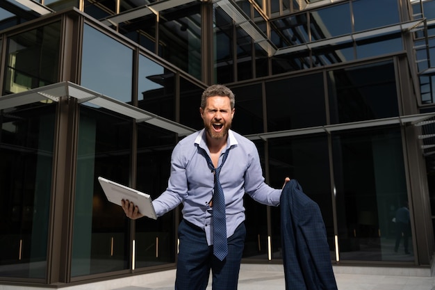 Homme d'affaires frustré criant de rage avec l'effondrement de l'ordinateur et de la veste