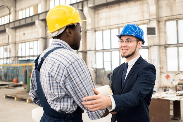 Homme d'affaires gai collaborant avec le directeur de la construction