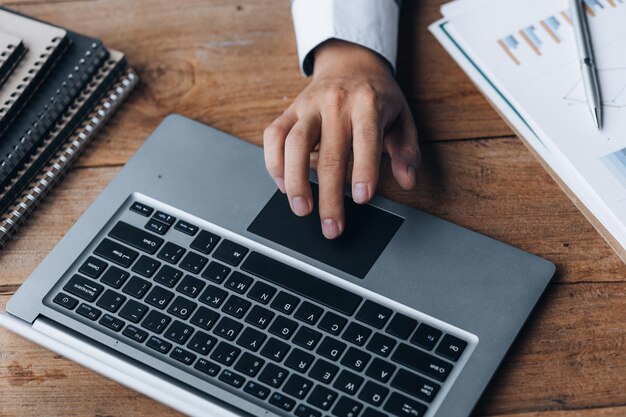 Homme d'affaires en gros plan travaillant dans une salle privée Il tape sur un clavier d'ordinateur portable Il utilise un messager pour discuter avec un partenaire Concept d'utilisation de la technologie dans la communication