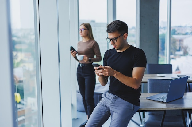 Un homme d'affaires heureux et détendu avec un téléphone dans les mains un étudiant à son bureau une table dans un café une personne calme et positive une détente une pause un rêve un repos de l'ordinateur ne ressentez pas de stress