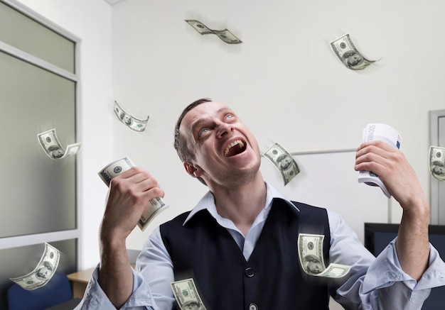 Photo un homme d'affaires heureux détient de l'argent et des rêves au bureau