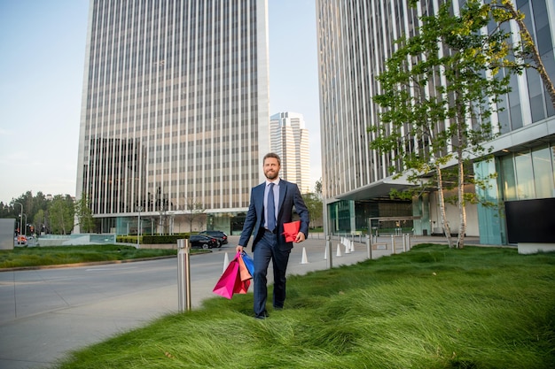 Homme d'affaires heureux de la journée des hommes avec vente de forfaits et surprise de réduction pour elle