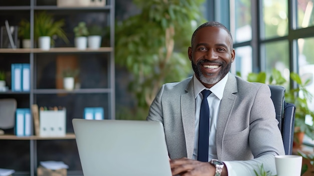 Un homme d'affaires heureux avec un ordinateur portable au bureau.