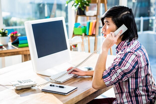 Homme d&#39;affaires hipster ayant un appel téléphonique au bureau