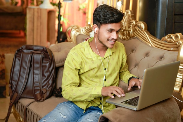 Homme d'affaires indien souriant à l'aide d'un ordinateur portable