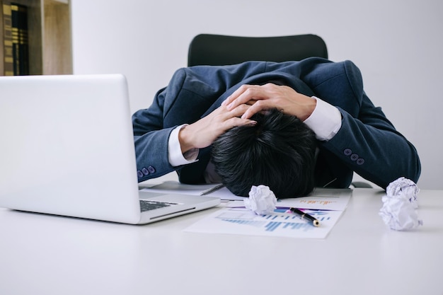 Un homme d'affaires inquiet avec un ordinateur portable sur la table du bureau.
