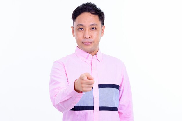 Homme d'affaires japonais avec chemise rose isolé contre le mur blanc