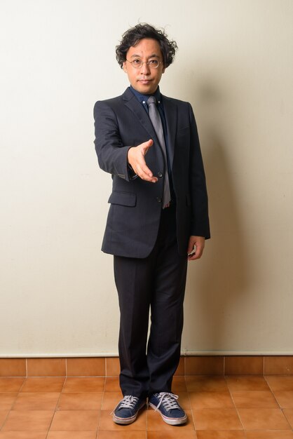 Homme d'affaires japonais en costume avec des cheveux bouclés à l'intérieur