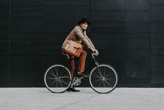 Homme d'affaires jeune beau avec son vélo moderne.