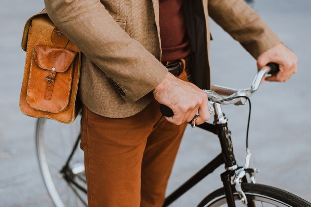 Homme d'affaires jeune beau avec son vélo moderne.