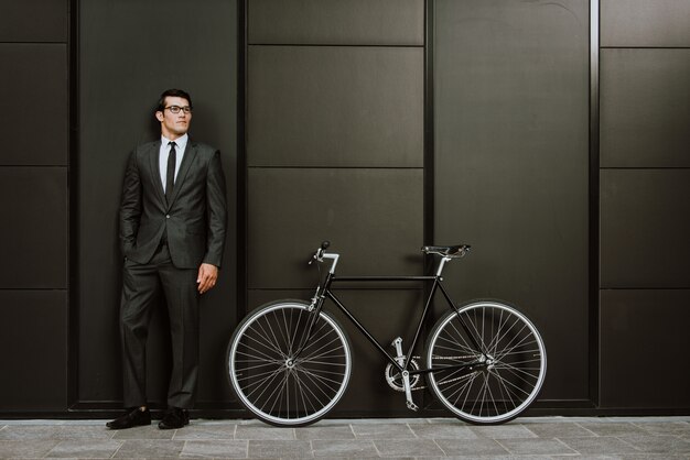 Homme d'affaires jeune beau avec son vélo moderne.