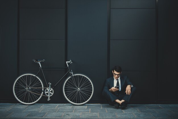 Homme d'affaires jeune beau avec son vélo moderne.