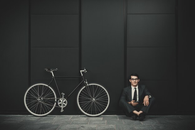 Homme d'affaires jeune beau avec son vélo moderne.