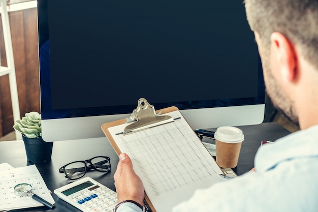 Homme d'affaires jeune homme assis à sa table de travail au bureau