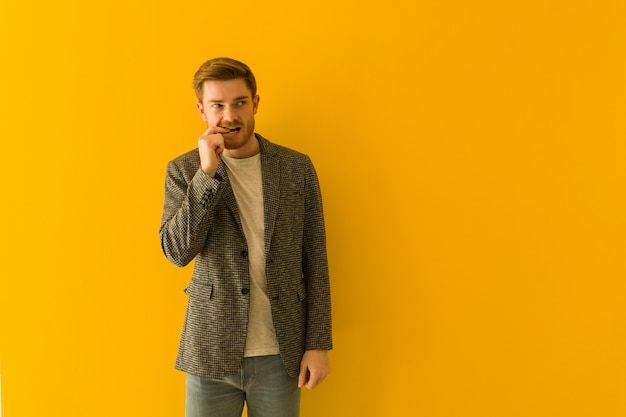 Homme d'affaires jeune rousse détendu penser à quelque chose en regardant un espace vide