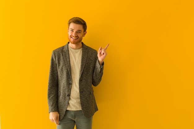 Homme d'affaires jeune rousse pointant sur le côté avec le doigt