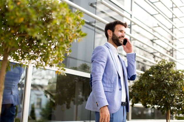 Homme d&#39;affaires jeune en utilisant un téléphone portable en plein air