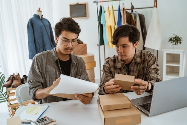 Homme d'affaires de jeunes asiatiques discutant sur le produit de l'emballage