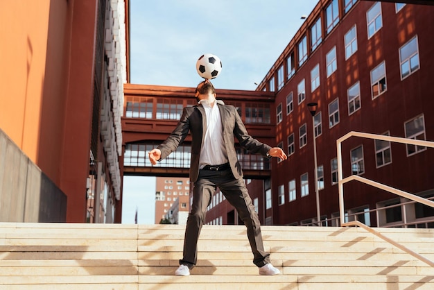 Homme d'affaires jouant avec un ballon de football et faisant des tours de style libre