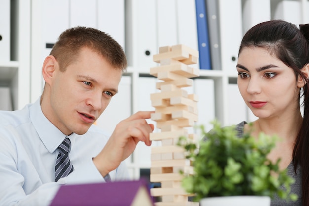 Homme d'affaires joue dans une stratégie de main jenga