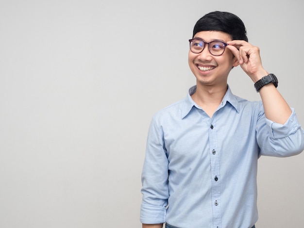 Un homme d'affaires joyeux tient ses lunettes en souriant et en regardant l'espace de copie