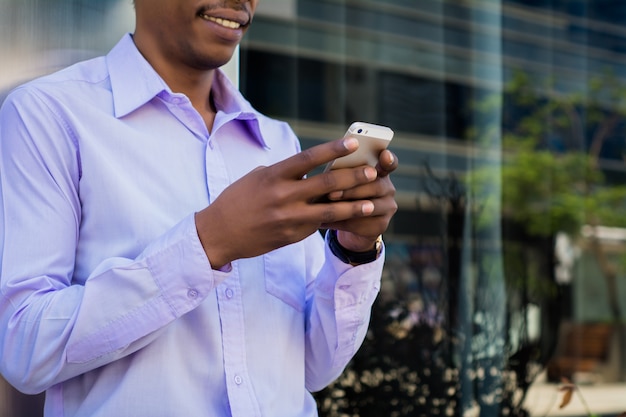 Homme d'affaires latin à l'aide de téléphone portable dans la ville