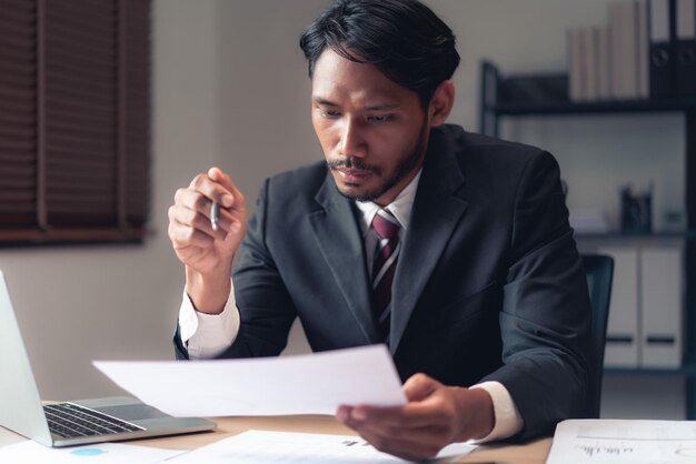 Homme d'affaires lecture de documents à la vérification et l'analyse sur les finances et la comptabilité de l'entreprise