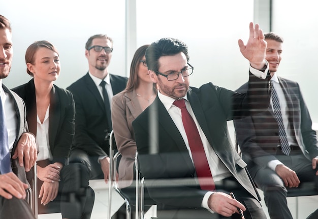 L'homme d'affaires lève la main à la conférence