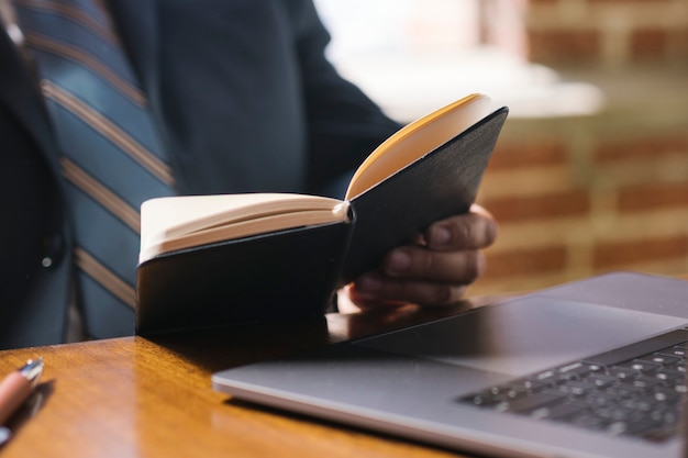 Homme d'affaires lisant un cahier au travail